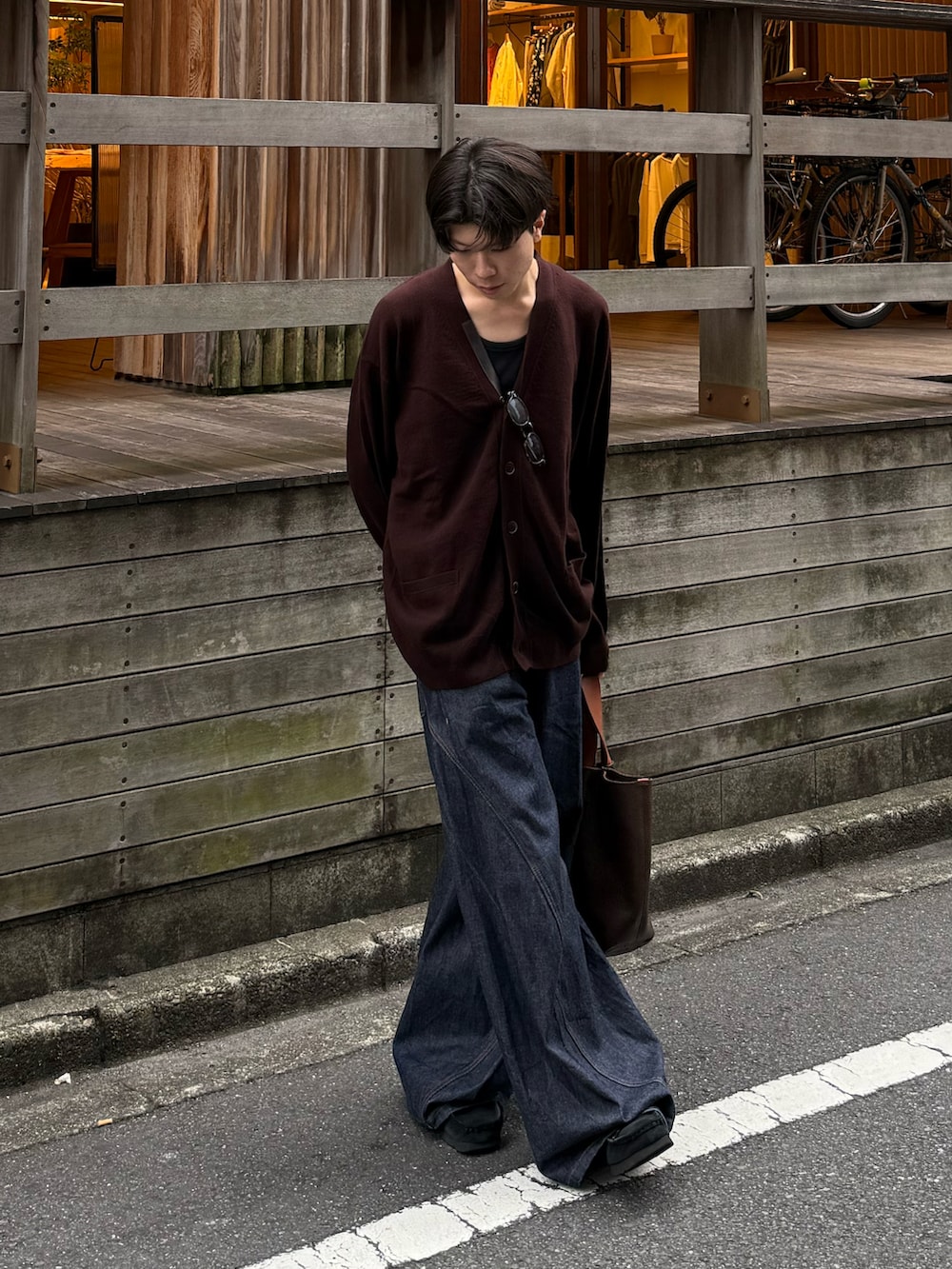 ブルー系のタンクトップ、ブルー系のデニムパンツ、ブラック系のモカシン/デッキシューズを着用したメンズの秋コーディネートの3枚目の写真