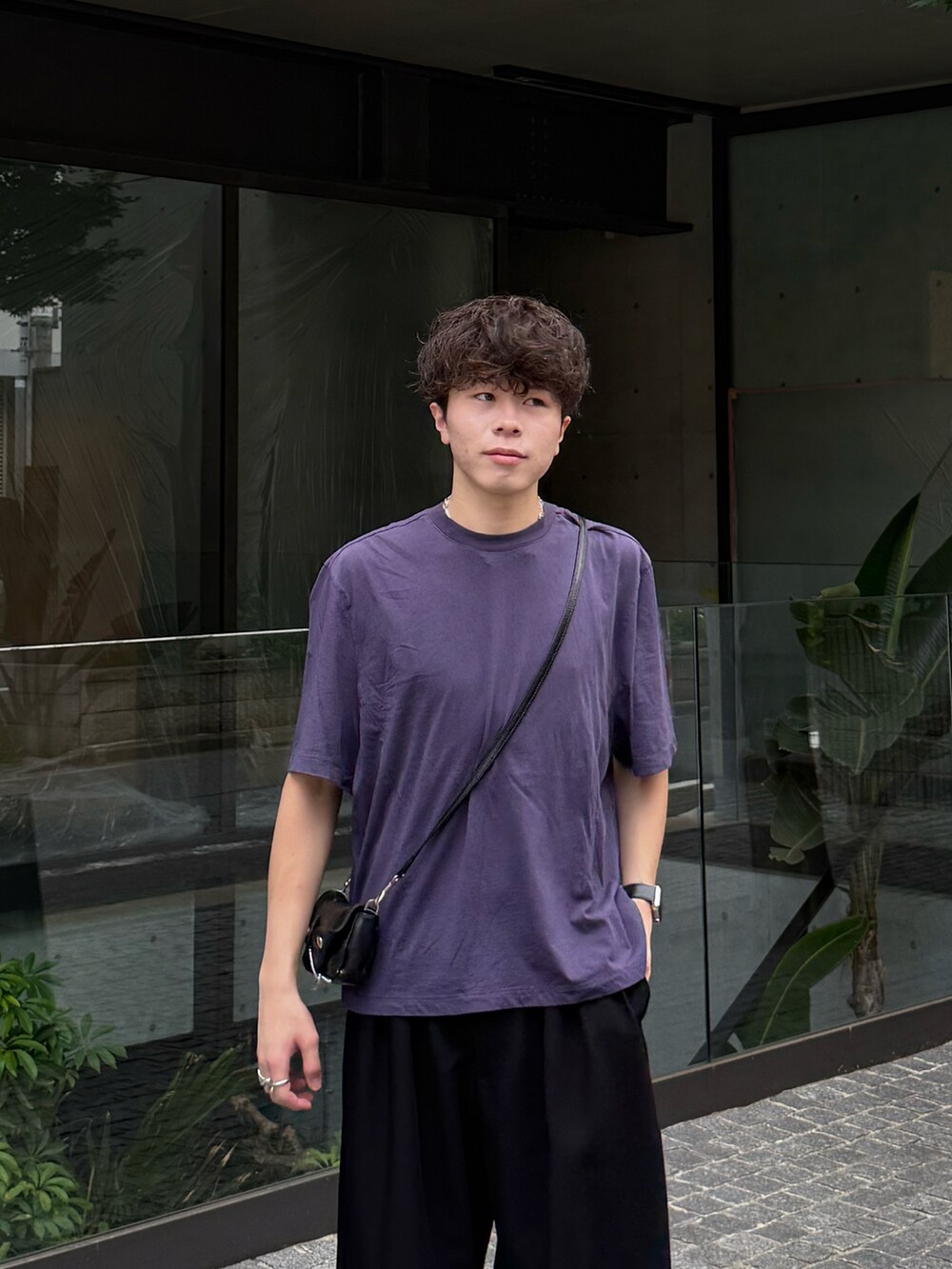 ブルー系のTシャツ/カットソー、ブラック系のスラックス、ブラウン系のスニーカーを着用したメンズの夏コーディネートの2枚目の写真