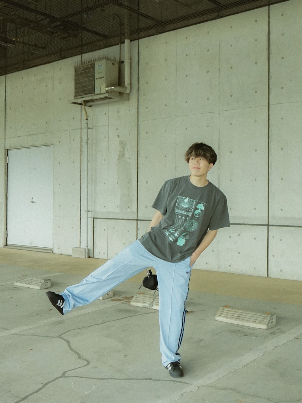 グレー系のTシャツ/カットソー、ブルー系のその他パンツ、ブラック系のショルダーバッグを着用したメンズの春コーディネートの3枚目の写真