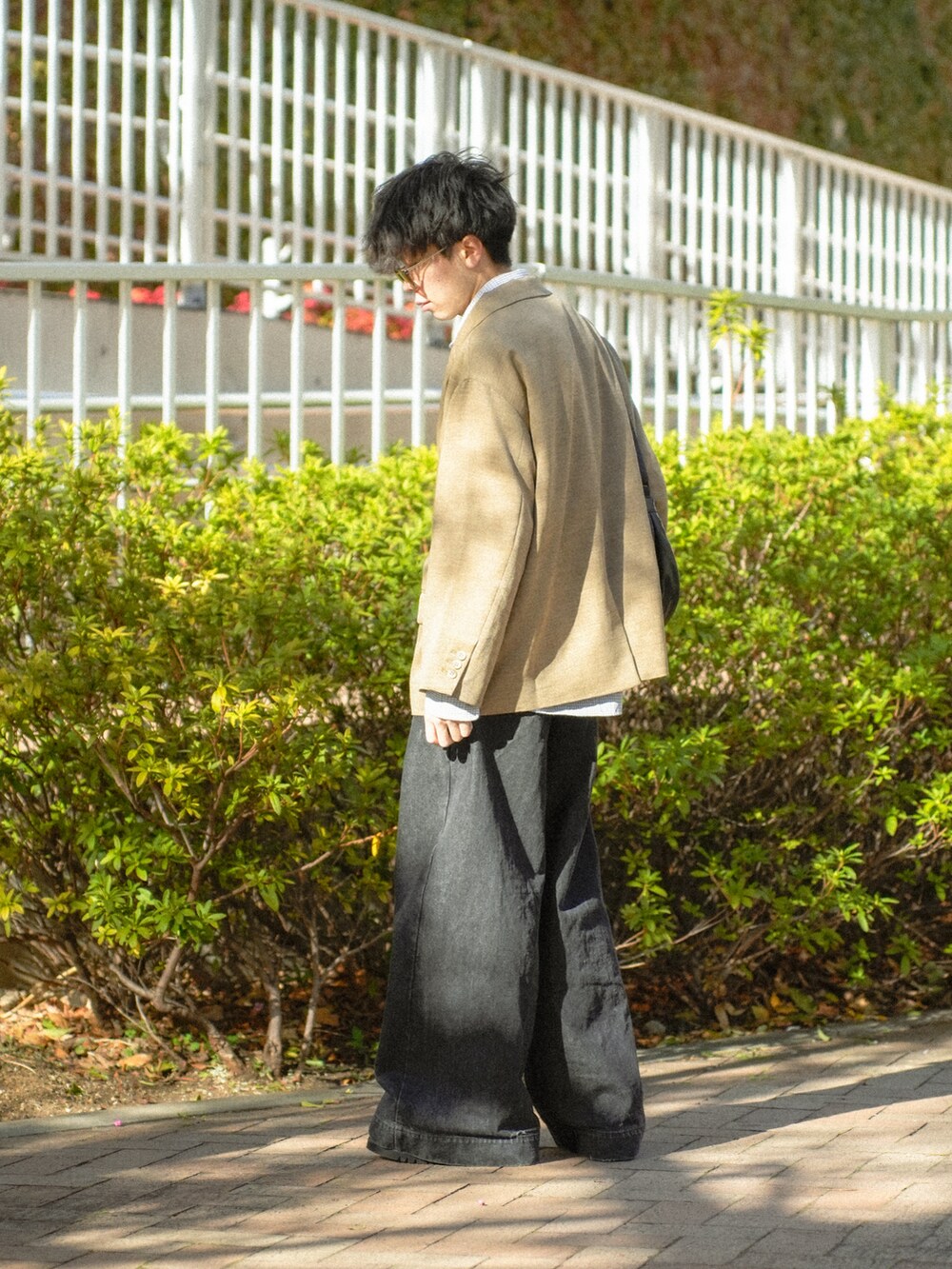 ブラウン系のテーラードジャケット、ブラック系のシャツ/ブラウス、ブラック系のデニムパンツを着用したメンズの春コーディネートの2枚目の写真