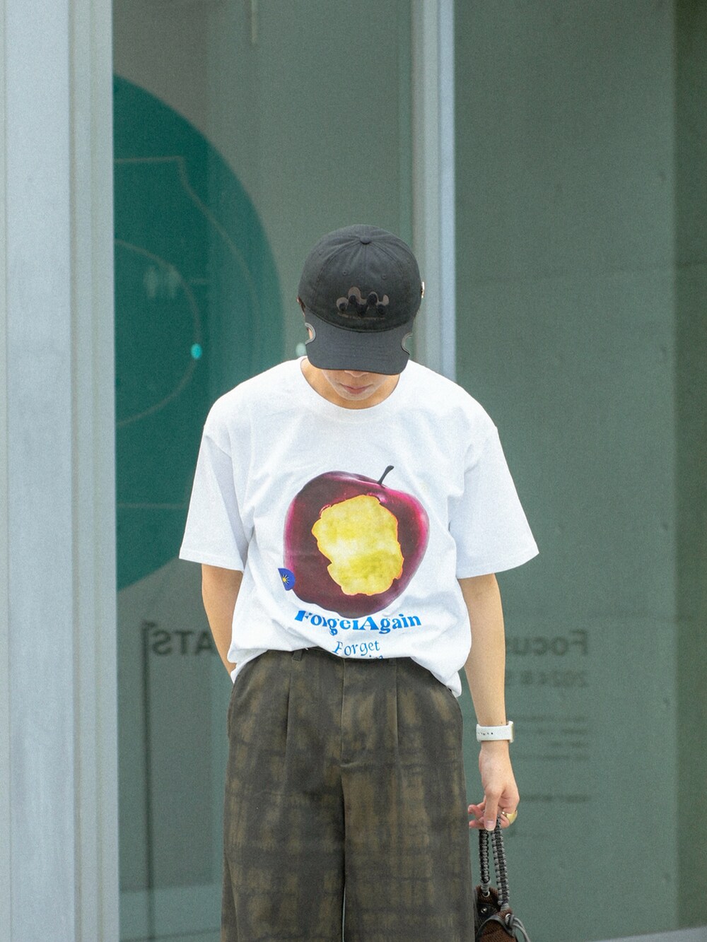 レッド系のTシャツ/カットソー、グリーン系のその他パンツ、ブラウン系のショルダーバッグを着用したメンズの夏コーディネートの4枚目の写真
