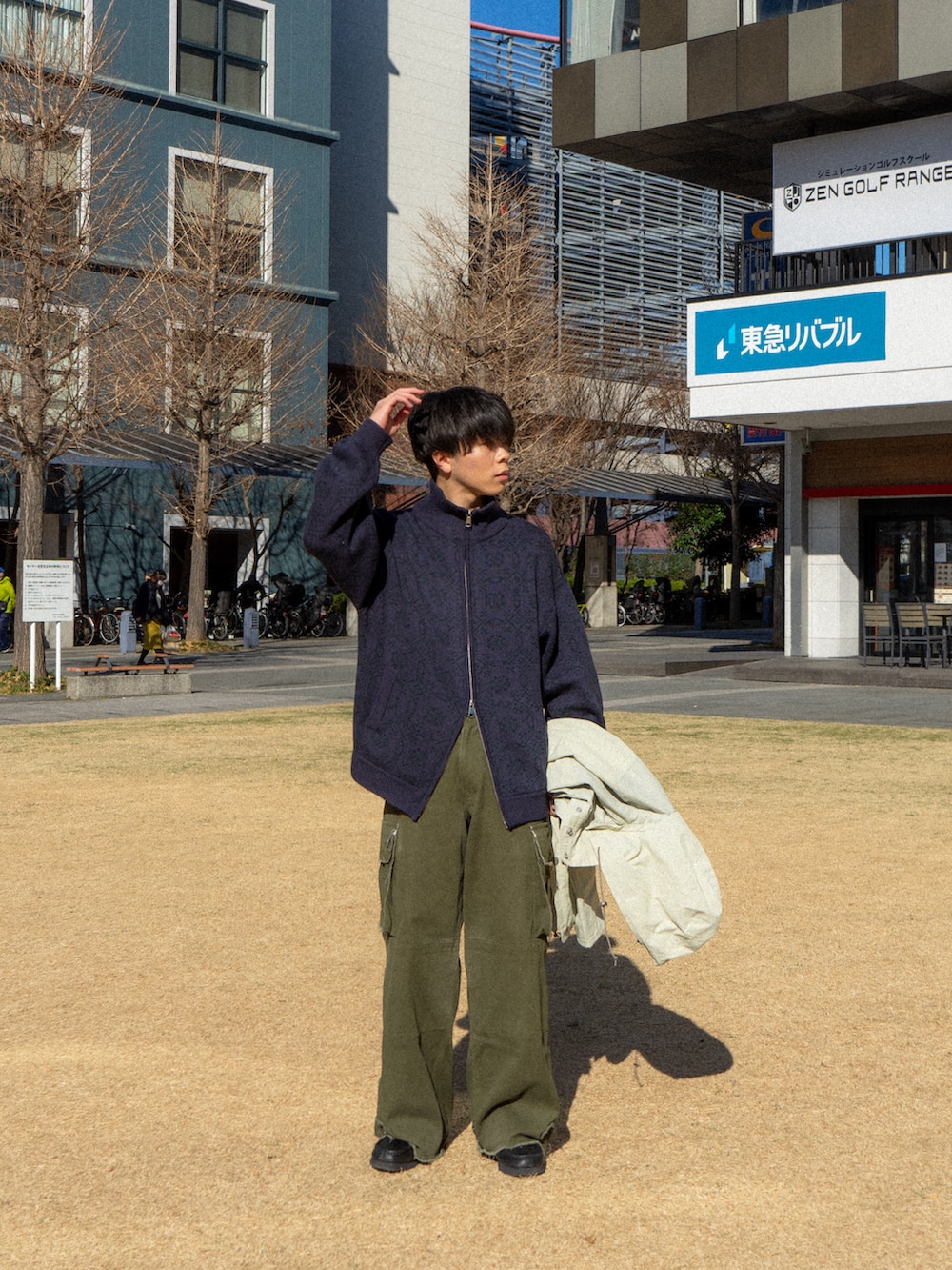 パープル系のニット/セーター、ベージュ系のマウンテンパーカー、グリーン系のカーゴパンツを着用したメンズの冬コーディネートの3枚目の写真