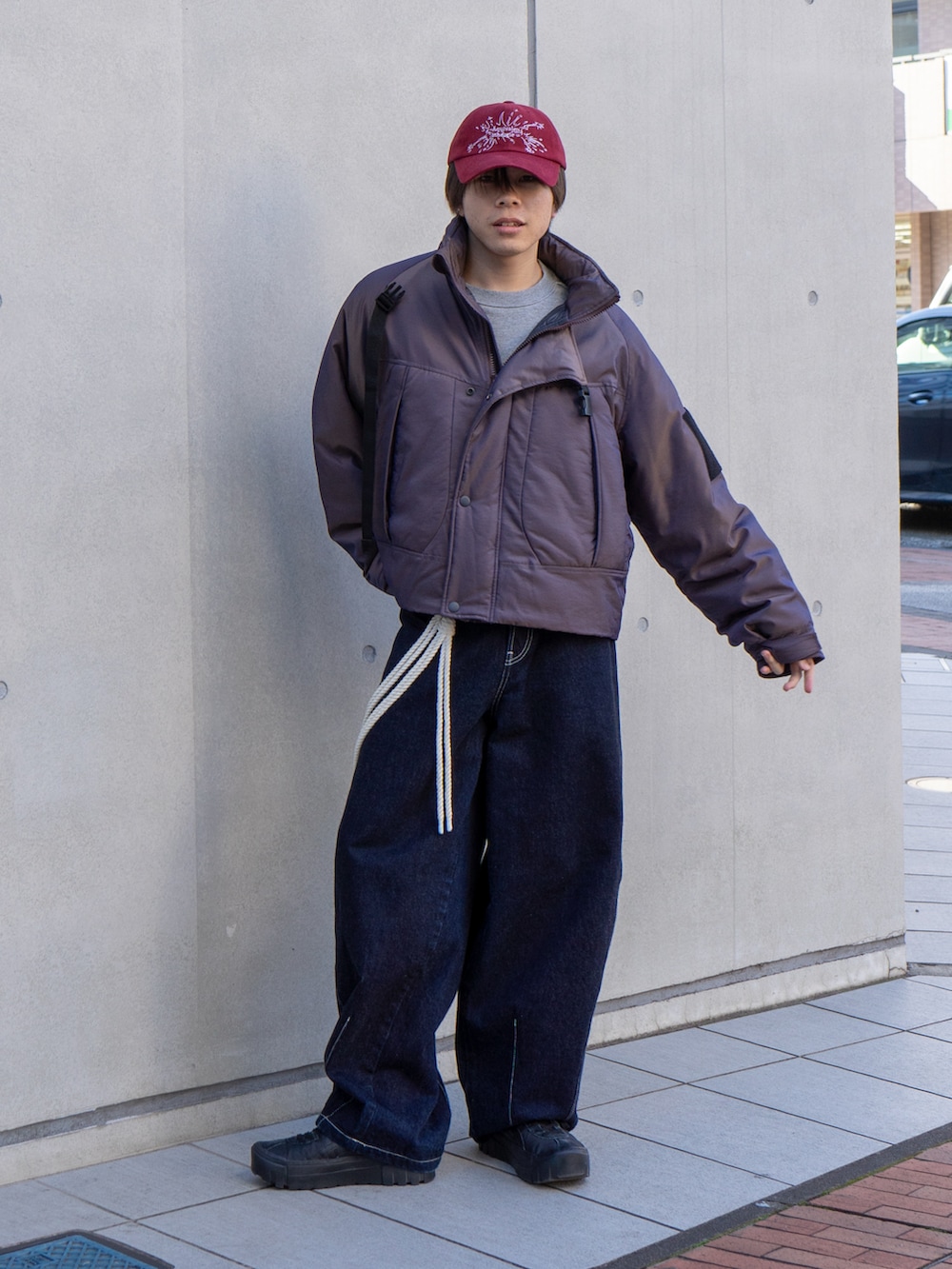 パープル系のブルゾン、グレー系のスウェット、ブラック系のスニーカーを着用したメンズの冬コーディネートの2枚目の写真