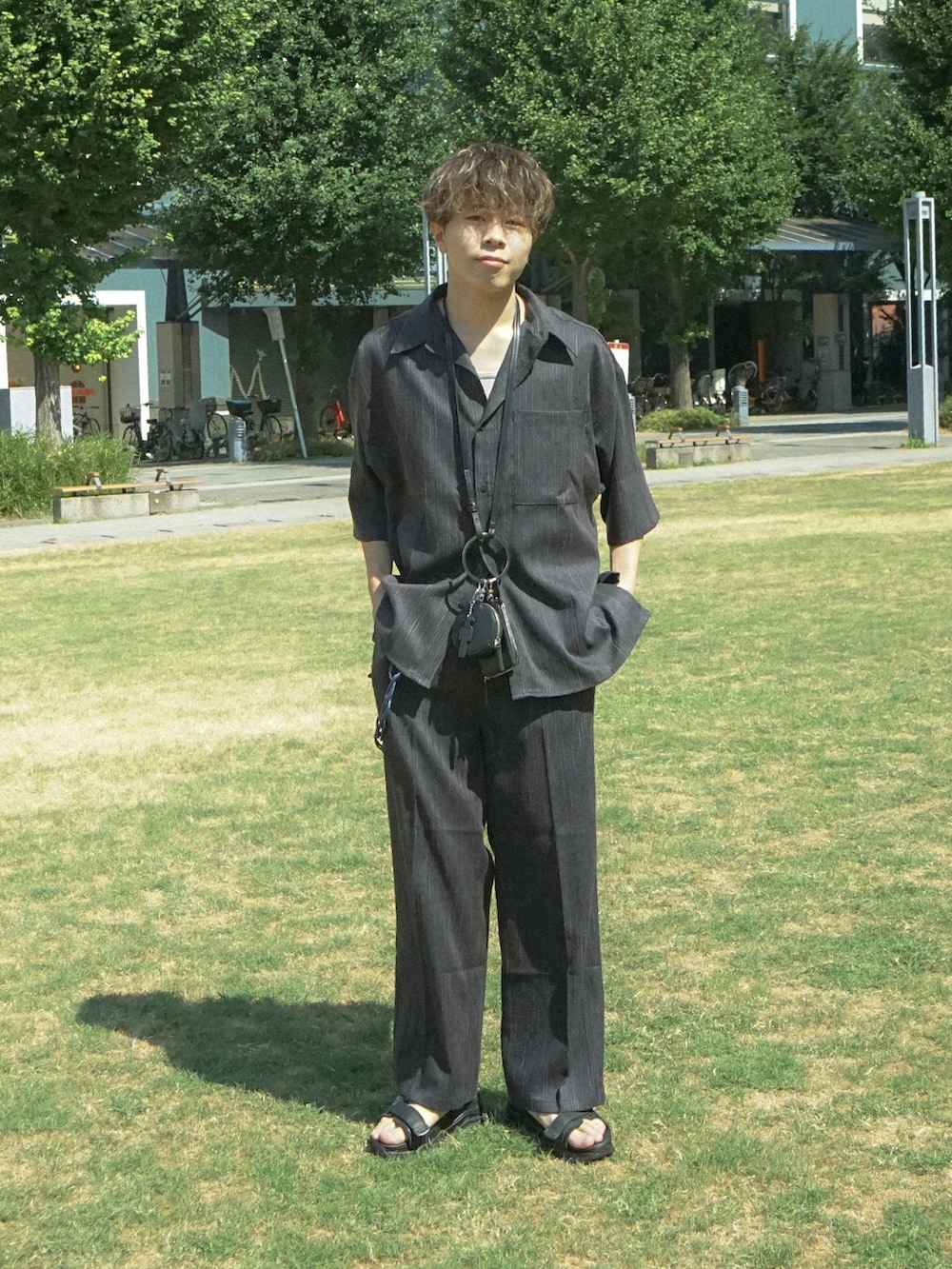 グレー系のシャツ/ブラウス、グレー系のスラックス、ブラック系のショルダーバッグを着用したメンズの夏コーディネートの2枚目の写真