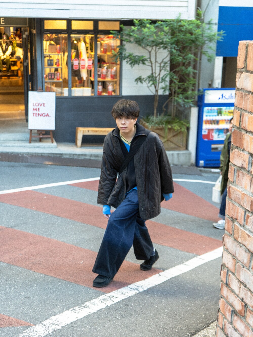 ブラック系のミリタリージャケット、ブルー系のニット/セーター、ブラック系のデニムパンツを着用したメンズの冬コーディネートの4枚目の写真