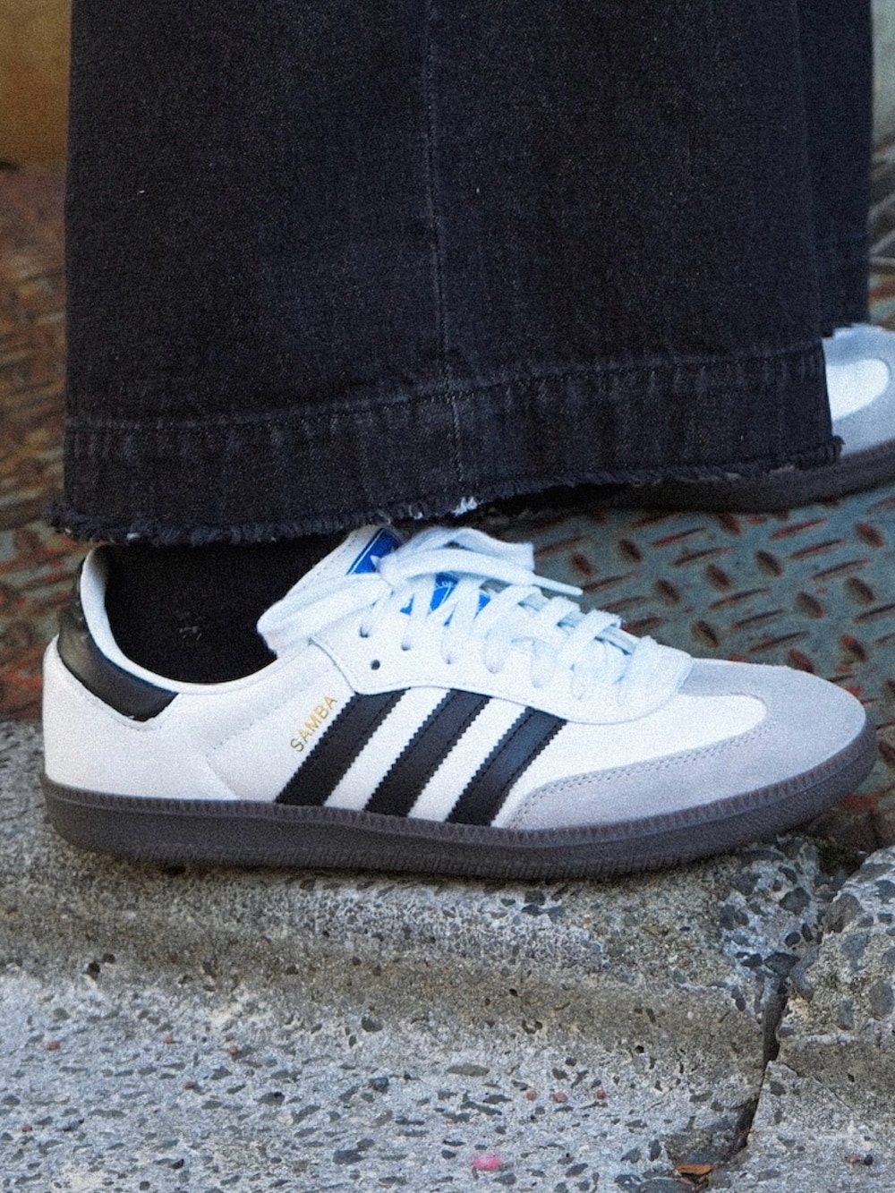 グリーン系のスウェット、ブラック系のデニムパンツ、グレー系のショルダーバッグを着用したメンズの冬コーディネートの3枚目の写真