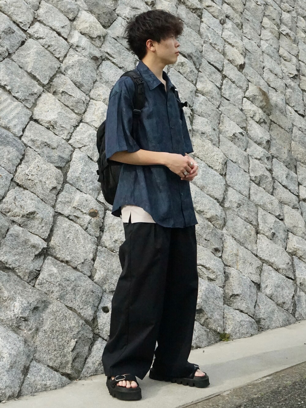 グリーン系のシャツ/ブラウス、グレー系のタンクトップ、ブラック系のバックパック/リュックを着用したメンズの春コーディネートの2枚目の写真