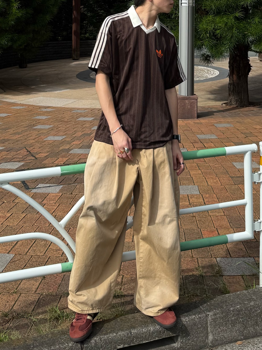 ブラウン系のTシャツ/カットソー、ベージュ系のチノパンツ、ブラウン系のスニーカーを着用したメンズの夏コーディネートの4枚目の写真