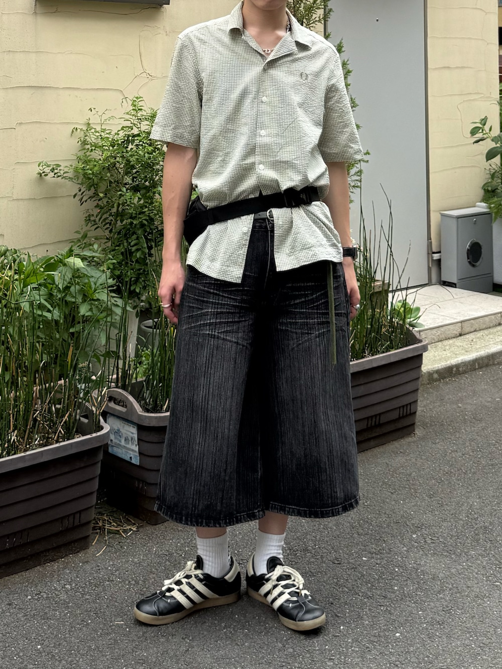 グリーン系のシャツ/ブラウス、グレー系のデニムパンツ、ブラック系のボディバッグ/ウエストポーチを着用したメンズの夏コーディネートの3枚目の写真