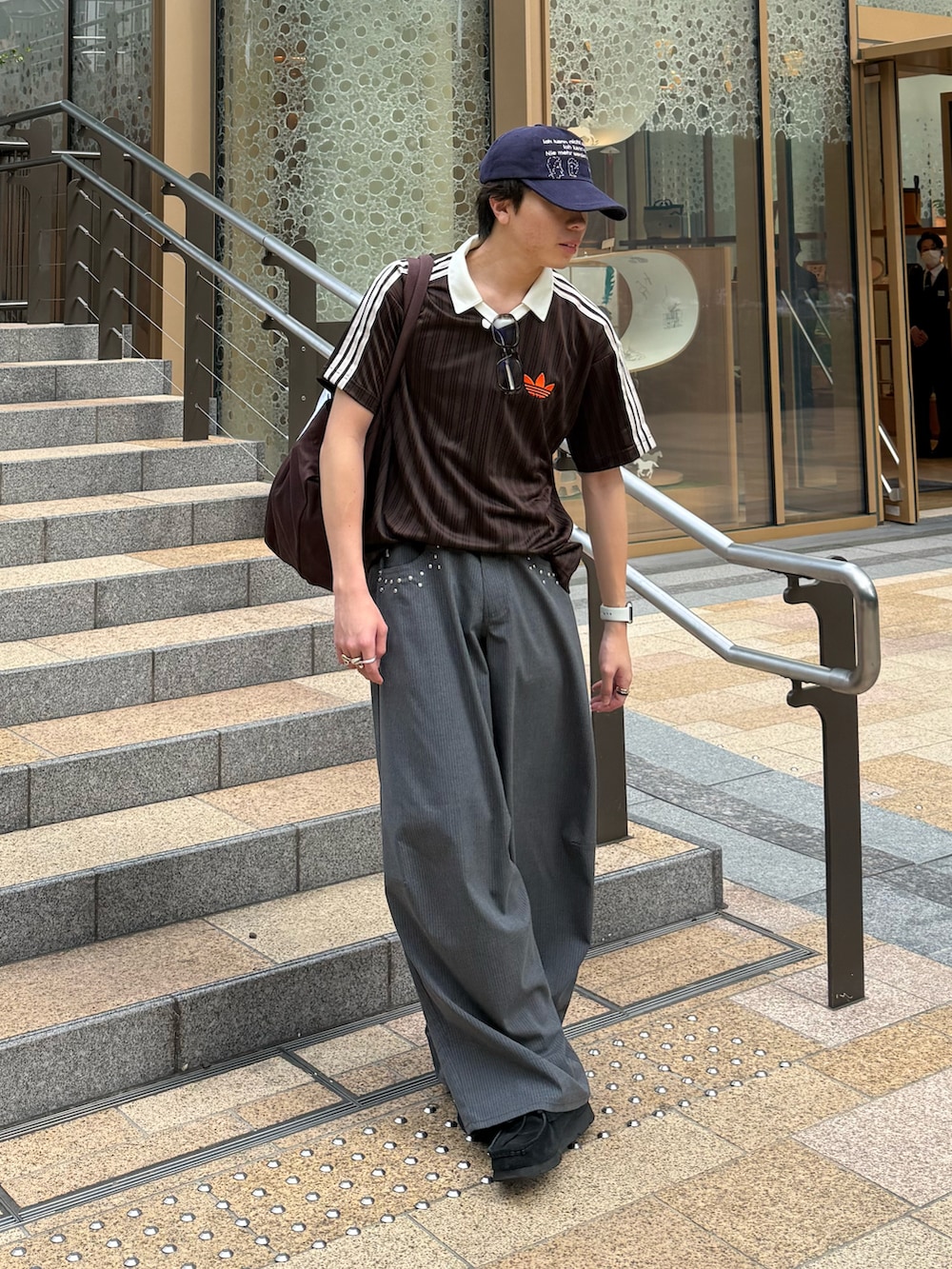 ブラウン系のTシャツ/カットソー、グレー系のスラックス、ブラウン系のトートバッグを着用したメンズの夏コーディネートの2枚目の写真