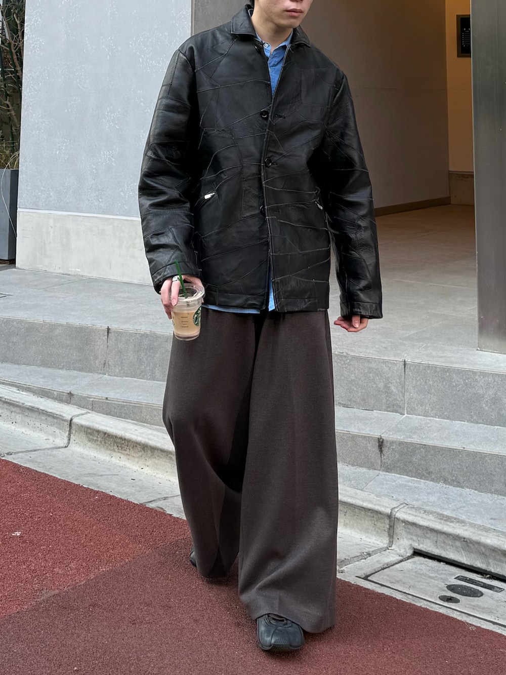 ブラック系のジャケット/アウター、ブルー系のシャツ/ブラウス、ブラウン系のスラックスを着用したメンズの春コーディネートの3枚目の写真