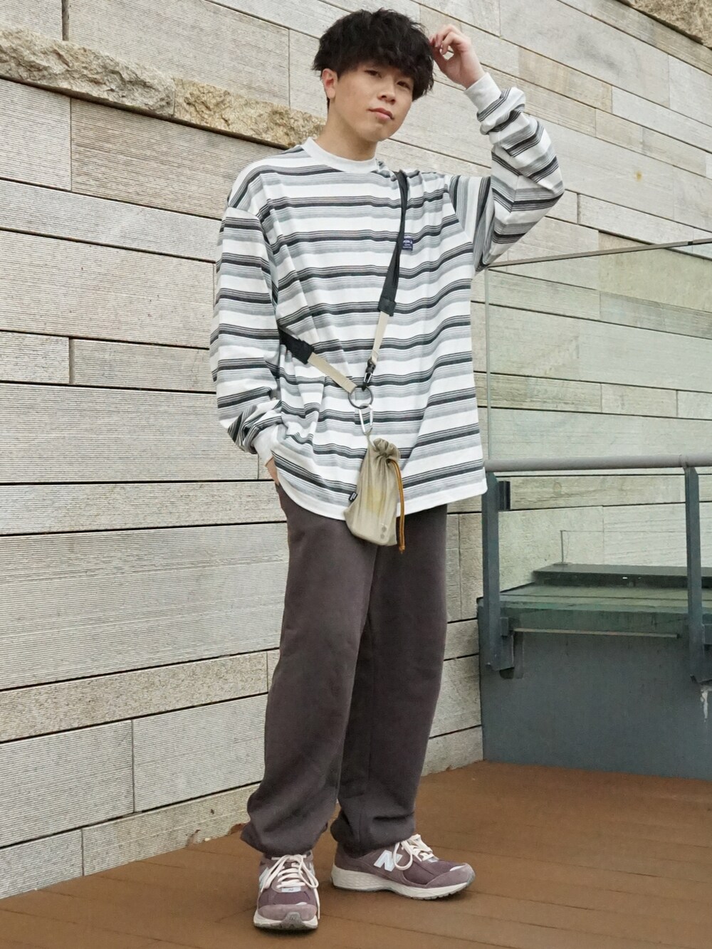 グレー系のTシャツ/カットソー、グレー系のスウェットパンツ、ベージュ系のショルダーバッグを着用したメンズの春コーディネートの2枚目の写真