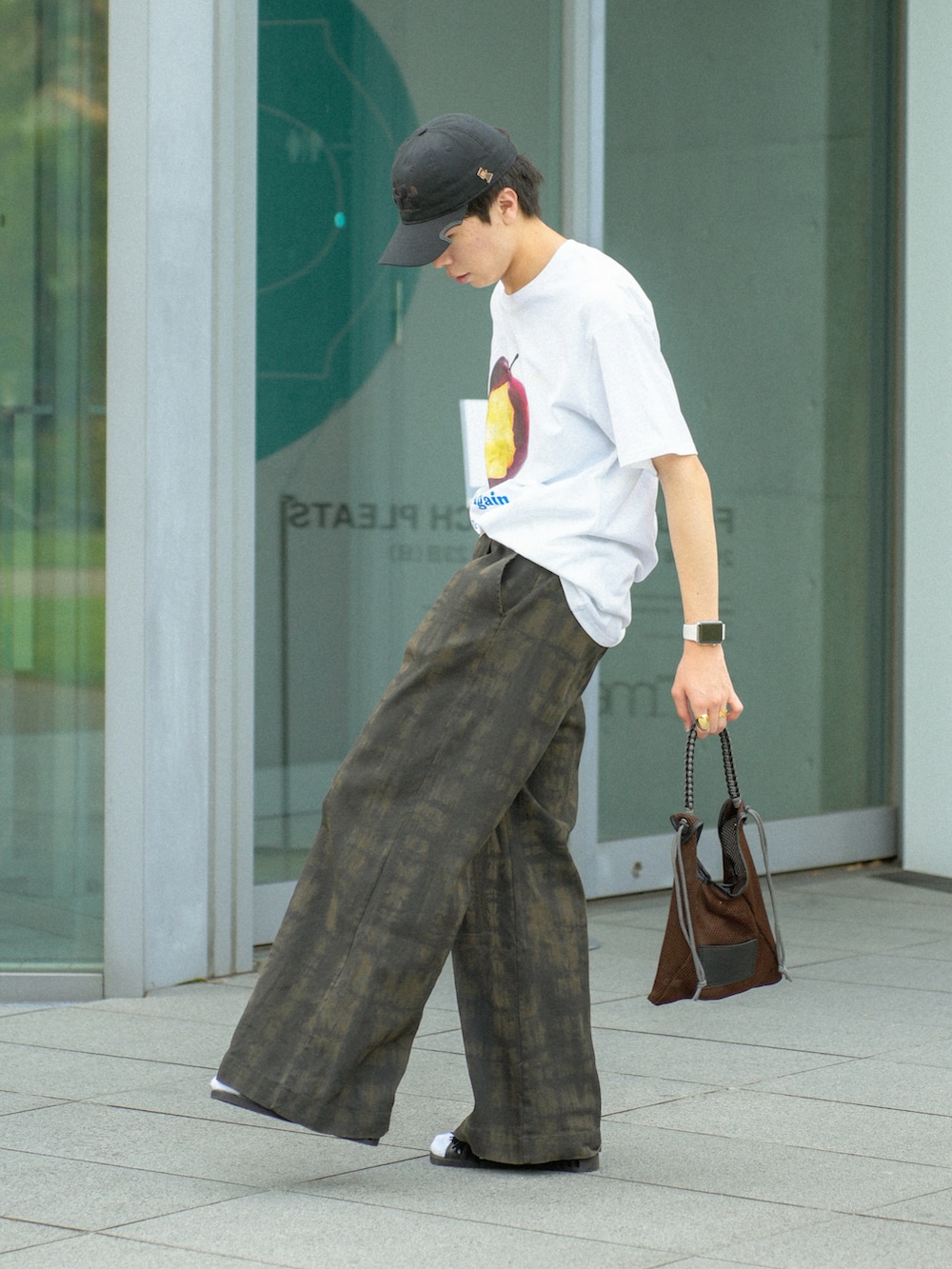 レッド系のTシャツ/カットソー、グリーン系のその他パンツ、ブラウン系のショルダーバッグを着用したメンズの夏コーディネートの2枚目の写真