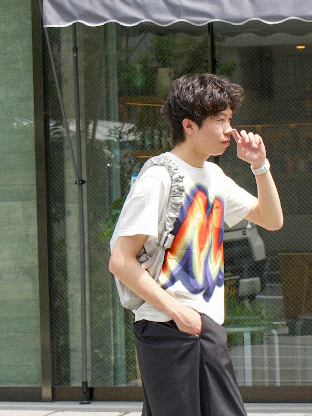 ホワイト系のTシャツ/カットソー、ブラック系のスラックス、ブラック系のスニーカーを着用したメンズの夏コーディネートの4枚目の写真