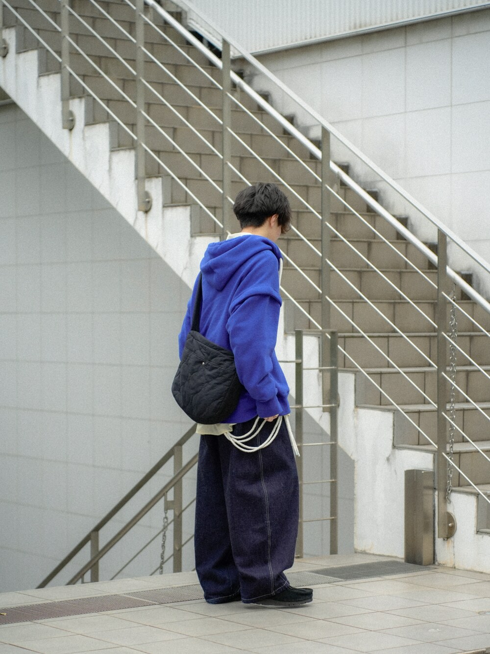 ブルー系のパーカー、イエロー系のシャツ/ブラウス、ブルー系のデニムパンツを着用したメンズの春コーディネートの3枚目の写真