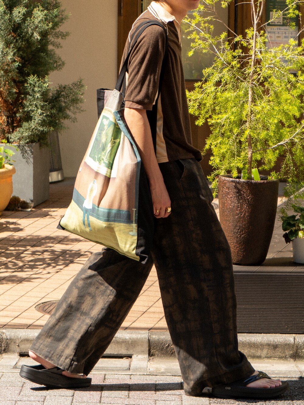 ブラウン系のポロシャツ、グリーン系のその他パンツ、ブラック系のトートバッグを着用したメンズの夏コーディネートの5枚目の写真