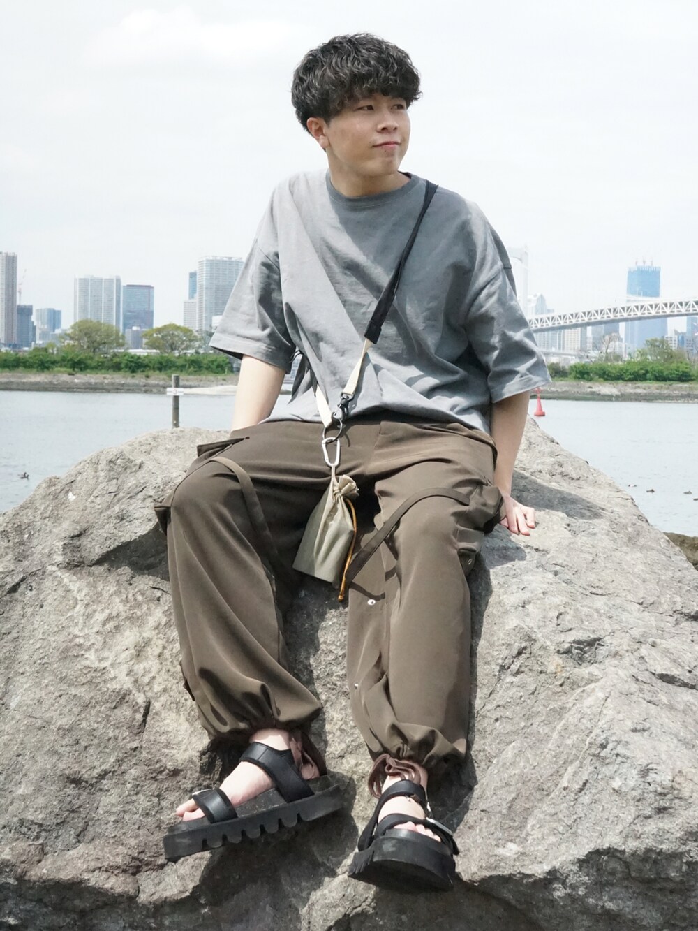 グレー系のTシャツ/カットソー、ベージュ系のショルダーバッグ、グリーン系のサロペット/オーバーオールを着用したメンズの春コーディネートの2枚目の写真