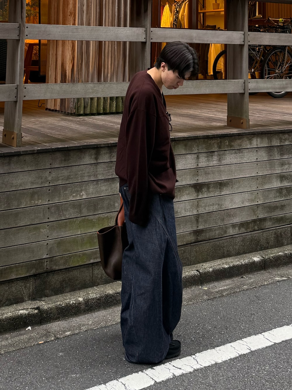 ブルー系のタンクトップ、ブルー系のデニムパンツ、ブラック系のモカシン/デッキシューズを着用したメンズの秋コーディネートの2枚目の写真