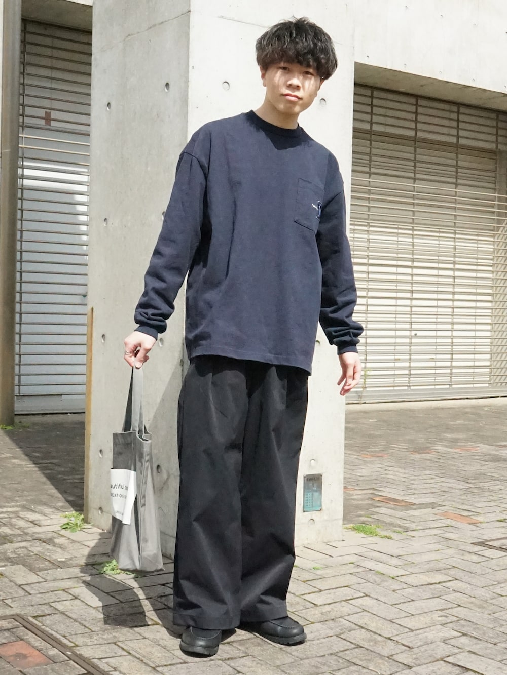 ブルー系のTシャツ/カットソー、ブラック系のその他パンツ、グレー系のトートバッグを着用したメンズの春コーディネートの2枚目の写真