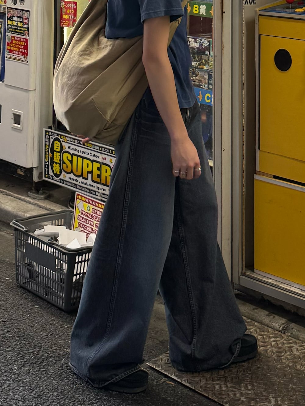 ブルー系のTシャツ/カットソー、ブルー系のデニムパンツ、ベージュ系のショルダーバッグを着用したメンズの夏コーディネートの4枚目の写真