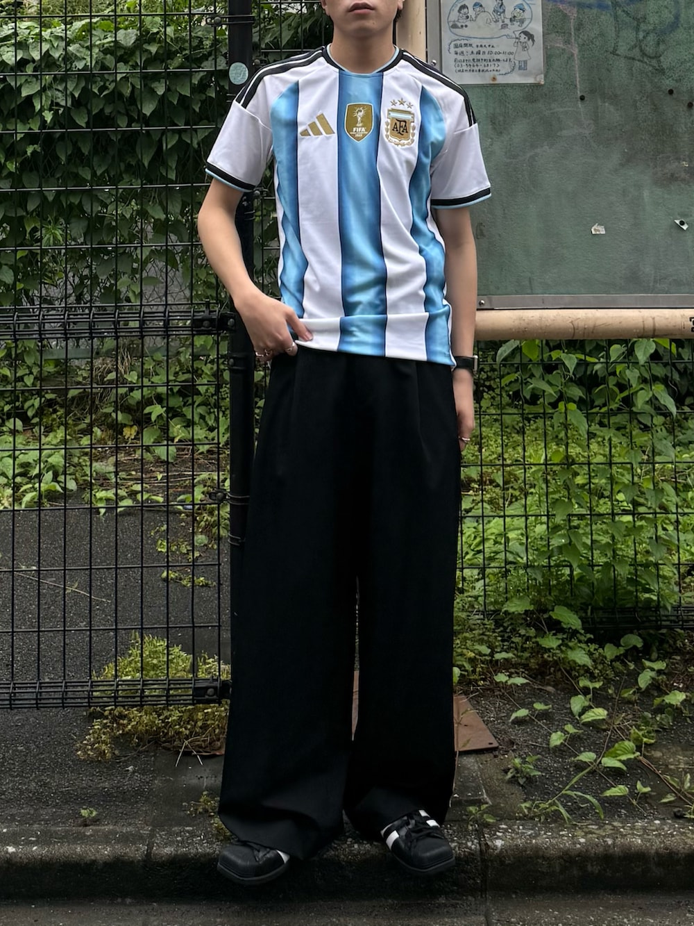 ホワイト系のTシャツ/カットソー、ブラック系のスラックス、ブラック系のスニーカーを着用したメンズの夏コーディネートの4枚目の写真
