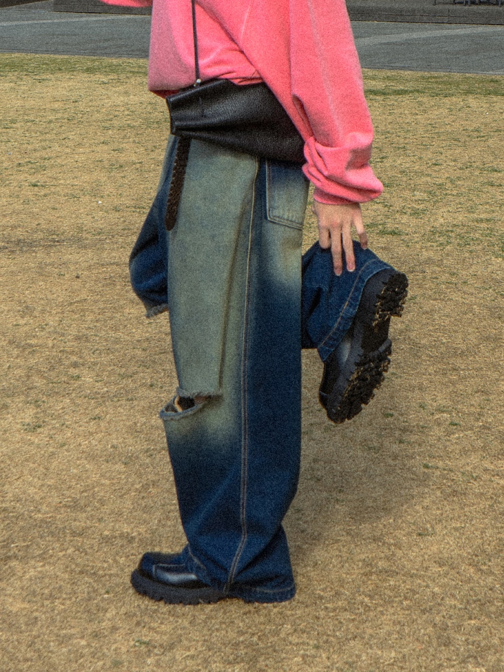 ピンク系のスウェット、ブルー系のデニムパンツ、ブラック系のショルダーバッグを着用したメンズの冬コーディネートの4枚目の写真