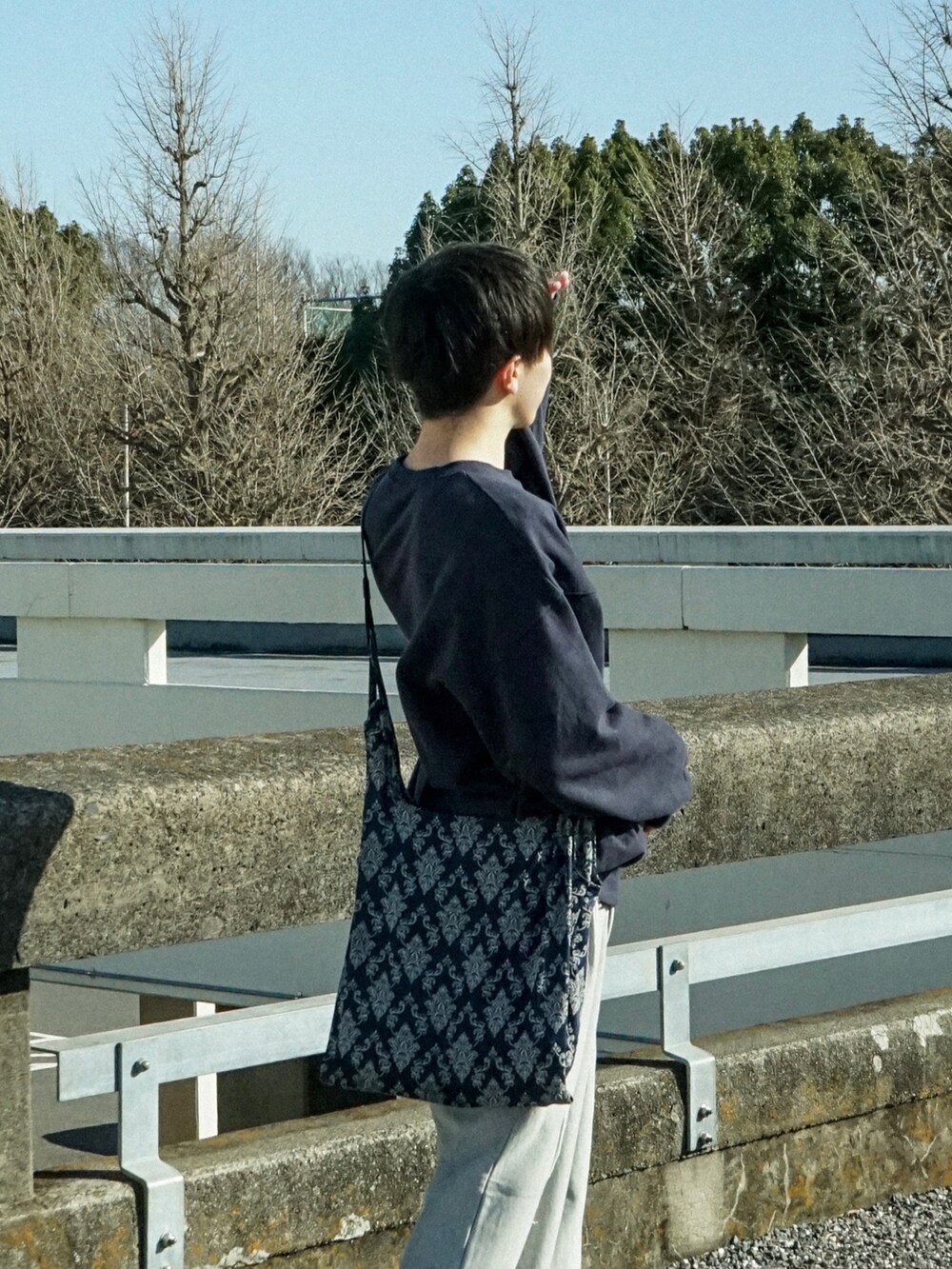 ブルー系のスウェット、グレー系のスウェットパンツ、ブルー系のショルダーバッグを着用したメンズの冬コーディネートの4枚目の写真