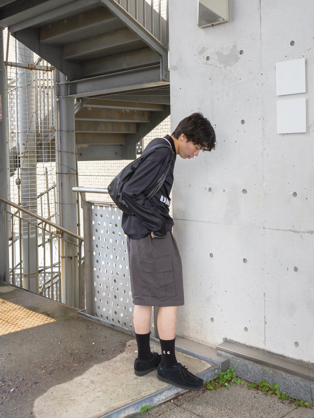 ブラック系のTシャツ/カットソー、グレー系のカーゴパンツ、ブラック系のその他シューズを着用したメンズの春コーディネートの3枚目の写真