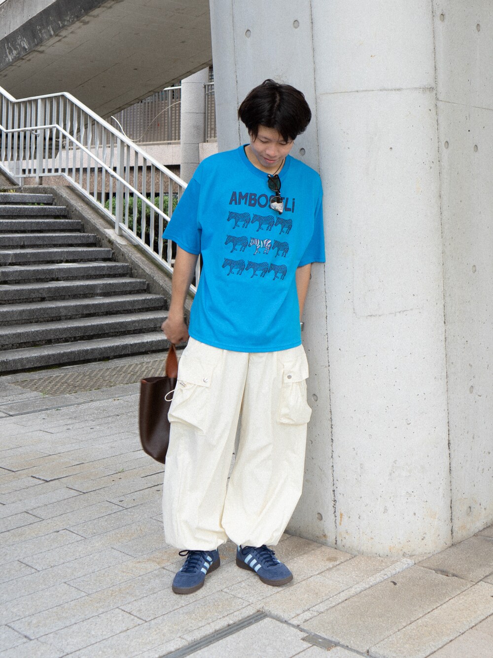 ブルー系のTシャツ/カットソー、ホワイト系のカーゴパンツ、ブラウン系のハンドバッグを着用したメンズの夏コーディネートの2枚目の写真