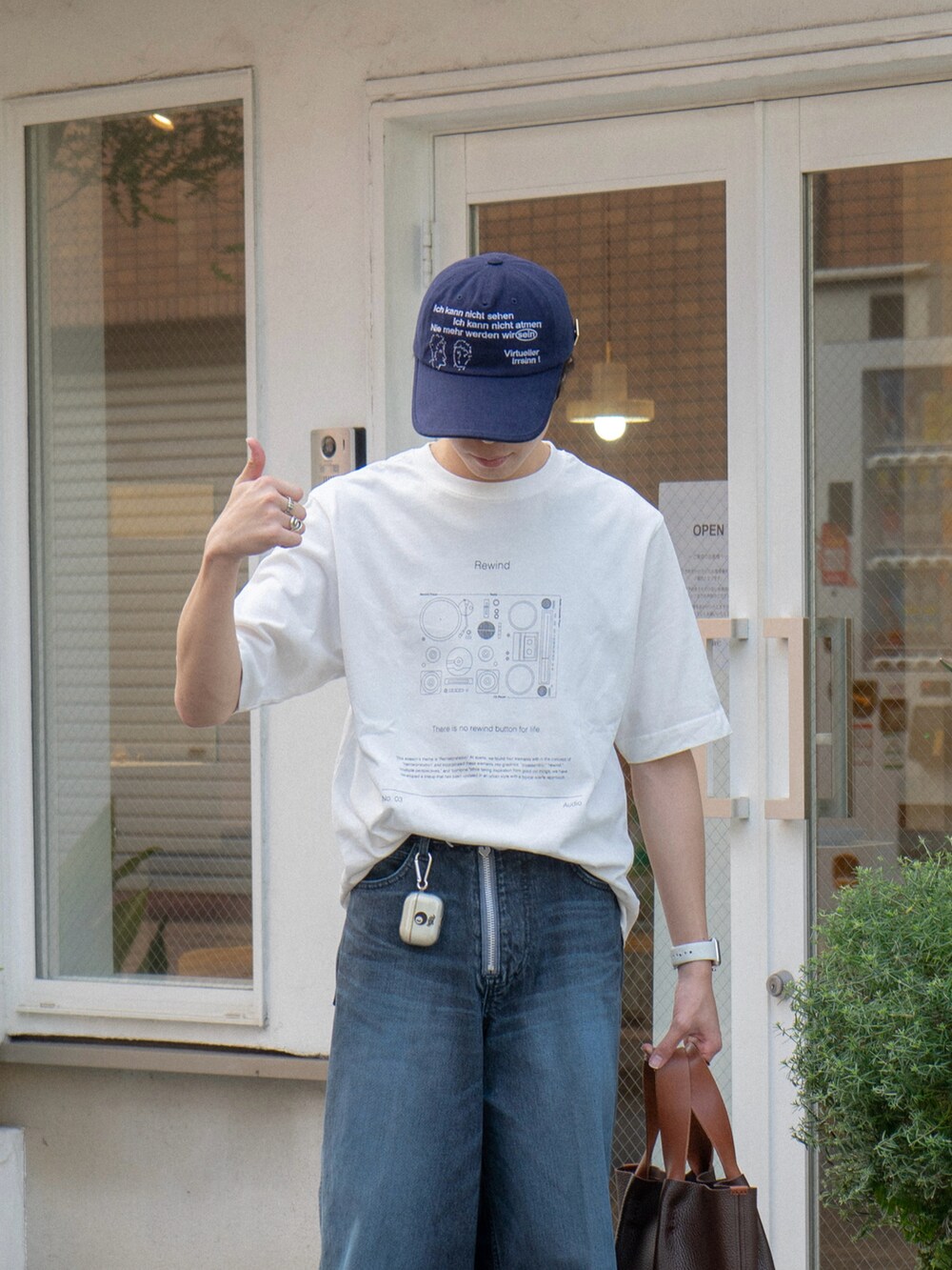 その他のTシャツ/カットソー、ブルー系のデニムパンツ、ブラウン系のハンドバッグを着用したメンズの夏コーディネートの3枚目の写真