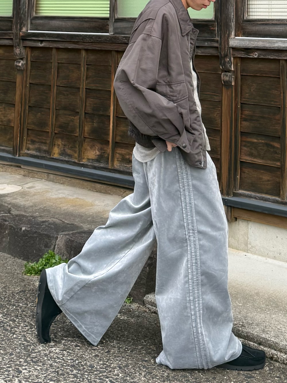 グレー系のスウェットパンツ、ブラック系のモカシン/デッキシューズ、グレー系のTシャツ/カットソーを着用したメンズの秋コーディネートの3枚目の写真