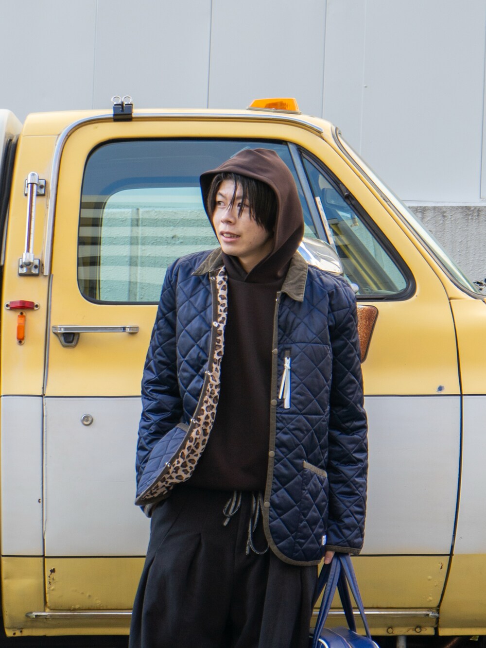 ブラック系のスウェットパンツ、ブルー系のボストンバッグ、ブラウン系のスニーカーを着用したメンズの冬コーディネートの4枚目の写真