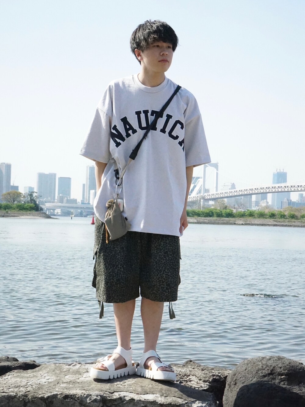 グレー系のTシャツ/カットソー、ベージュ系のショルダーバッグ、グリーン系のその他パンツを着用したメンズの春コーディネートの2枚目の写真