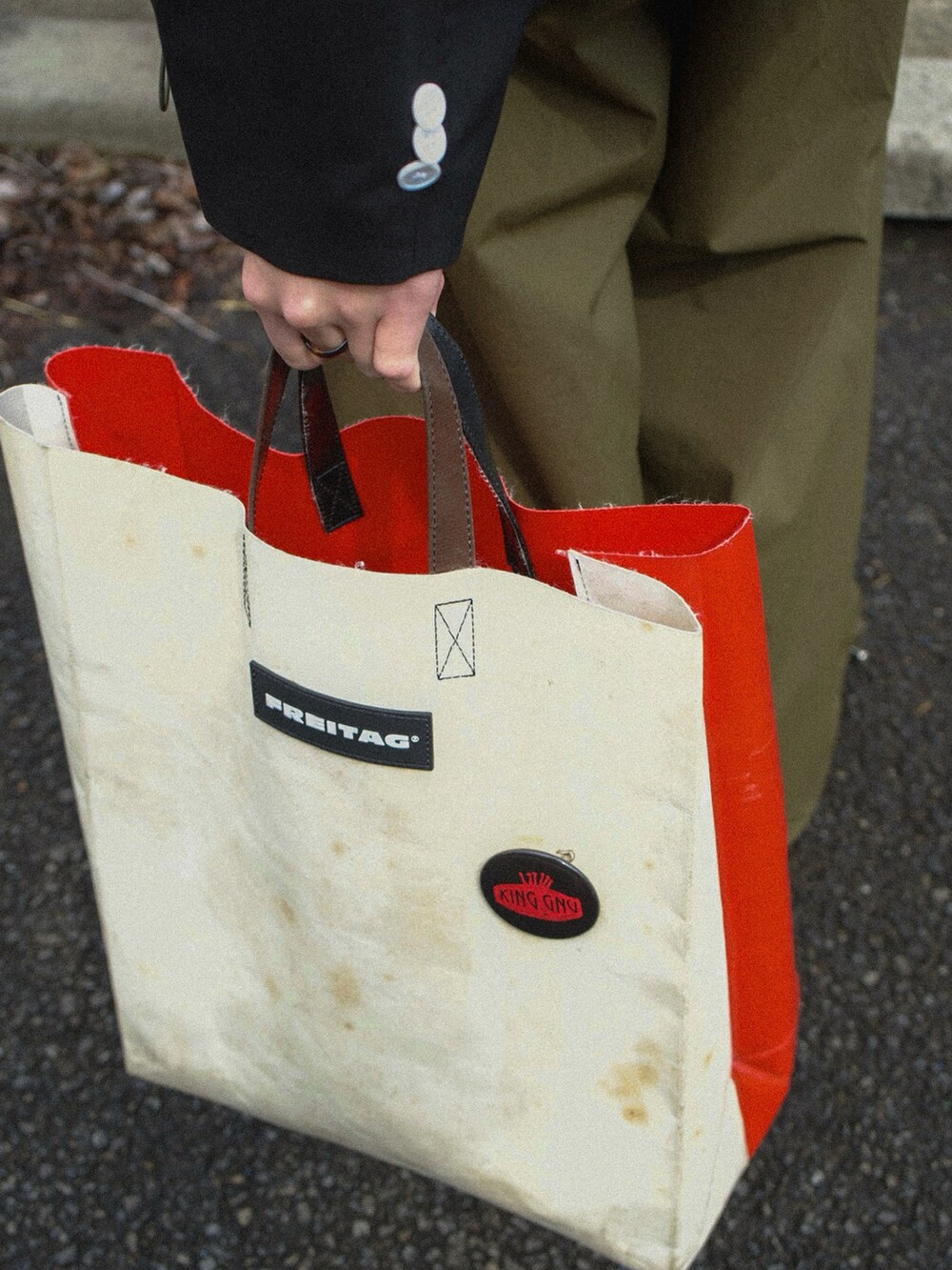 ブラック系のテーラードジャケット、ブラック系のポロシャツ、グリーン系のカーゴパンツを着用したメンズの春コーディネートの5枚目の写真