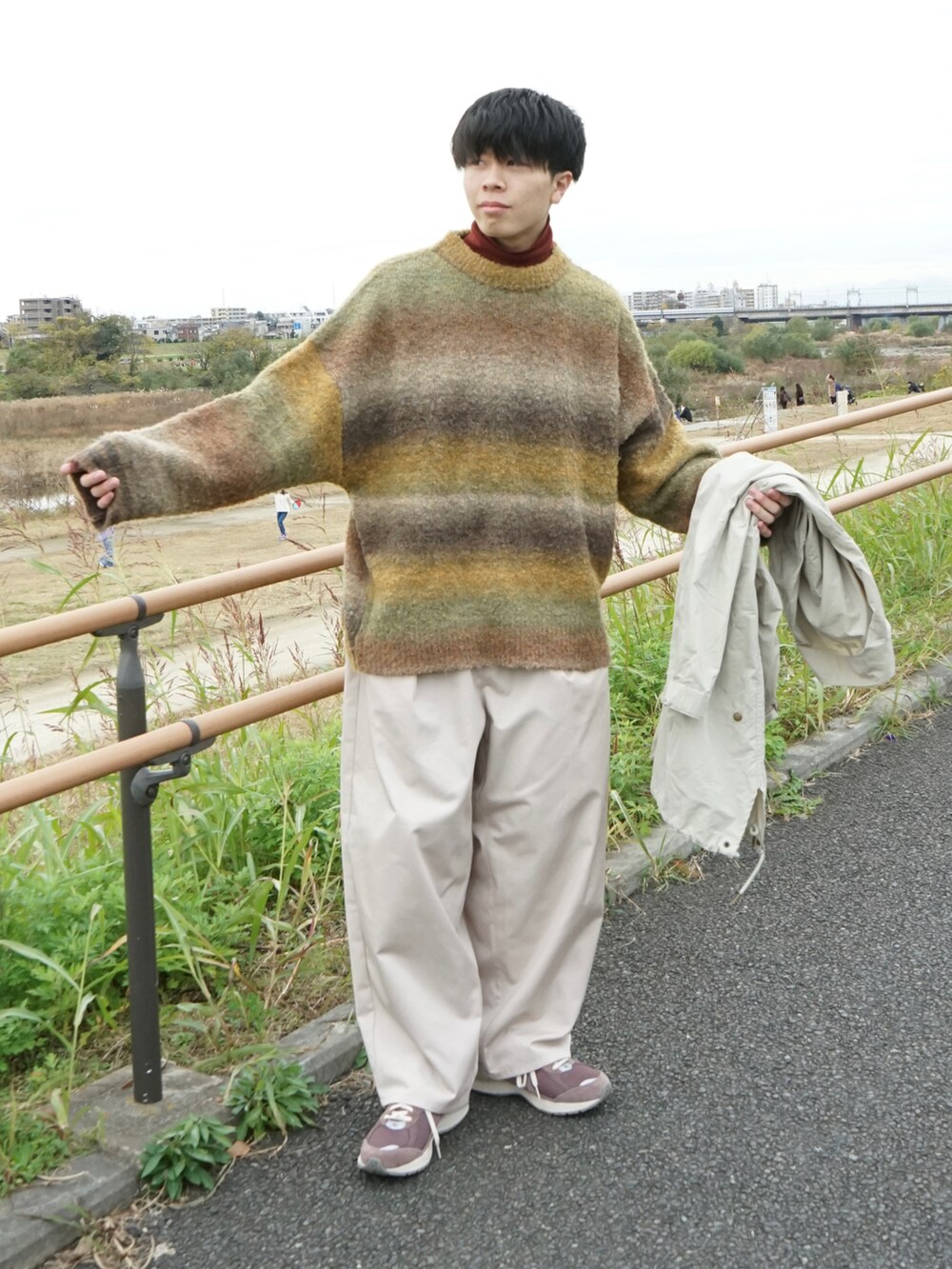 グリーン系のニット/セーター、レッド系のTシャツ/カットソー、ベージュ系のモッズコートを着用したメンズの冬コーディネートの3枚目の写真