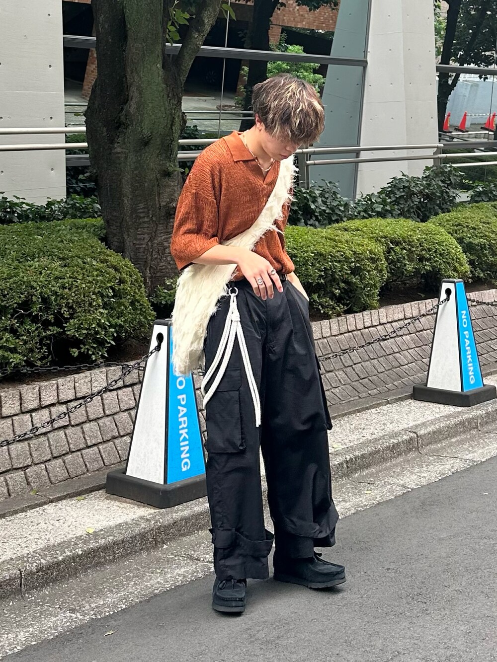 ブラウン系のポロシャツ、ブラック系のカーゴパンツ、ホワイト系のショルダーバッグを着用したメンズの夏コーディネートの3枚目の写真