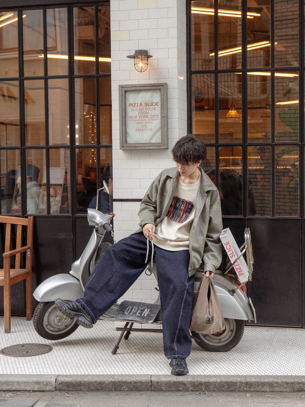 グレー系のブルゾン、ホワイト系のスウェット、ブルー系のデニムパンツを着用したメンズの冬コーディネートの3枚目の写真