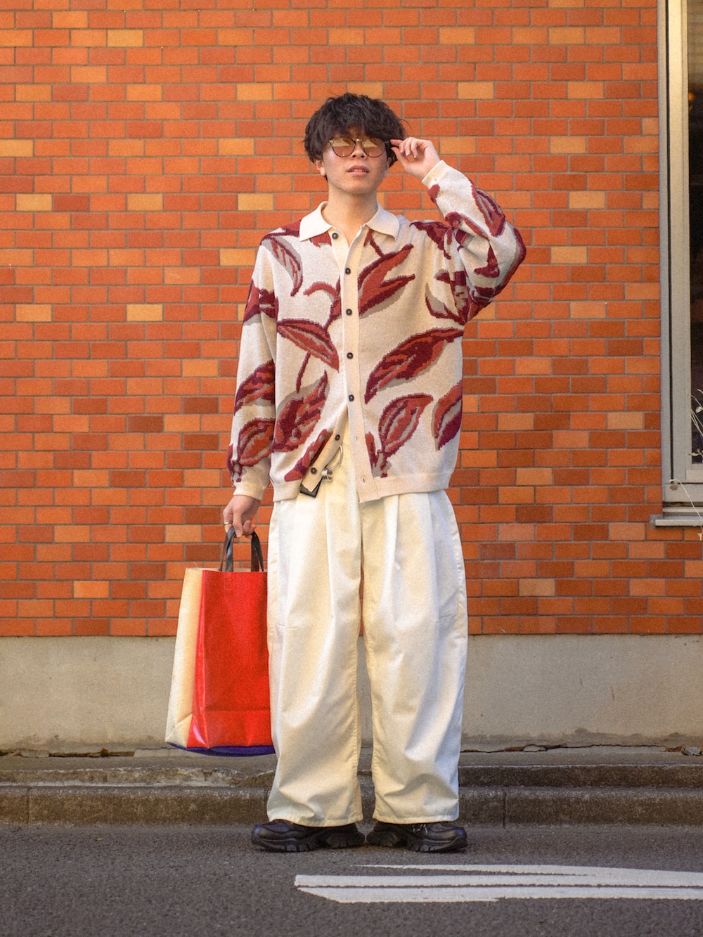 ホワイト系のカーディガン/ボレロ、ホワイト系のチノパンツ、ホワイト系のトートバッグを着用したメンズの春コーディネートの2枚目の写真