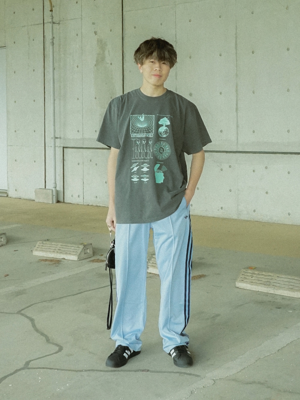 グレー系のTシャツ/カットソー、ブルー系のその他パンツ、ブラック系のショルダーバッグを着用したメンズの春コーディネートの2枚目の写真