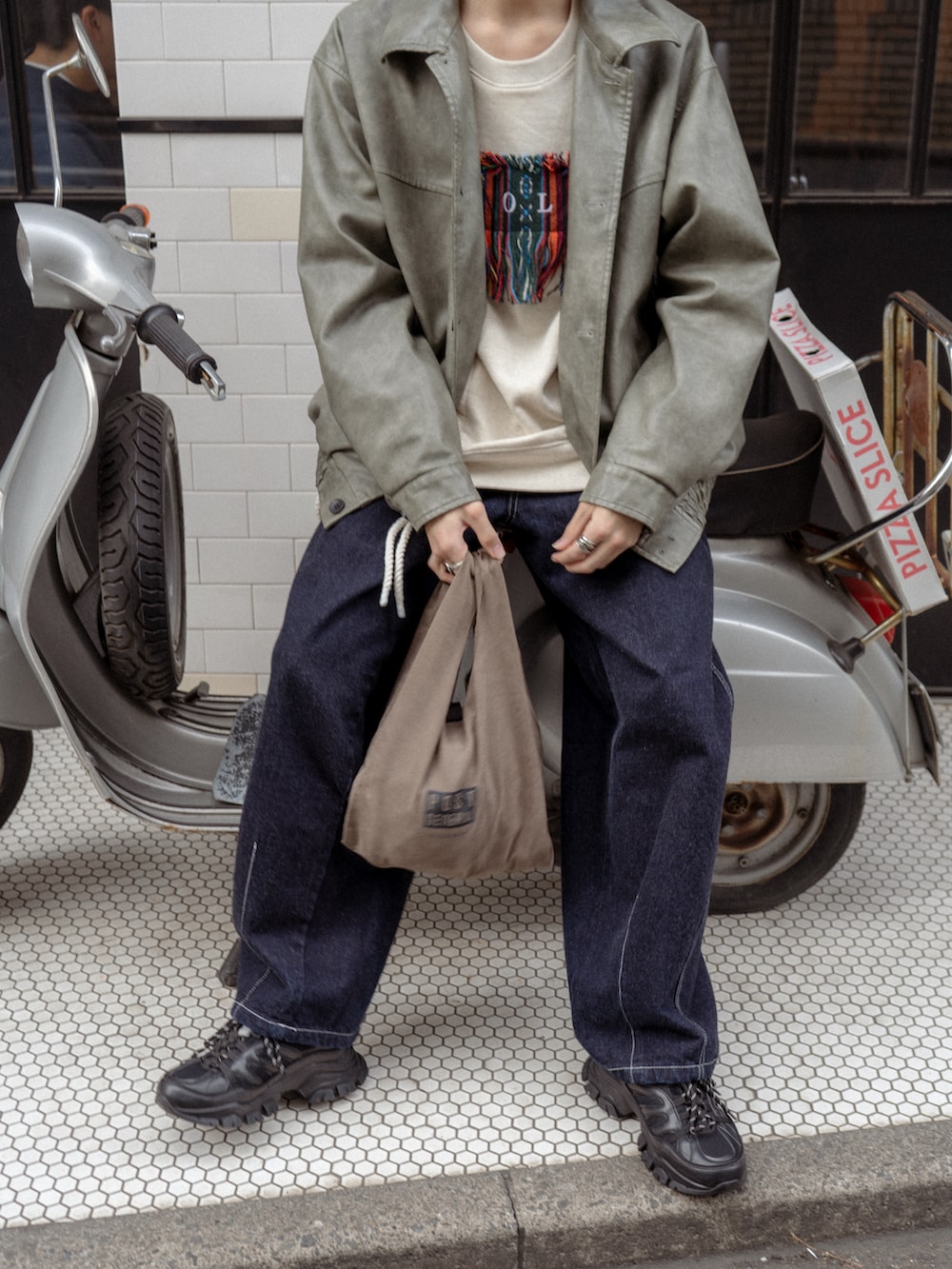 グレー系のブルゾン、ホワイト系のスウェット、ブルー系のデニムパンツを着用したメンズの冬コーディネートの4枚目の写真