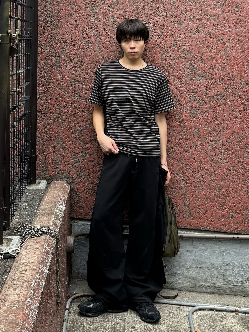 グリーン系のバックパック/リュック、ブラック系のTシャツ/カットソー、ブラック系のスウェットパンツを着用したメンズの秋コーディネートの3枚目の写真