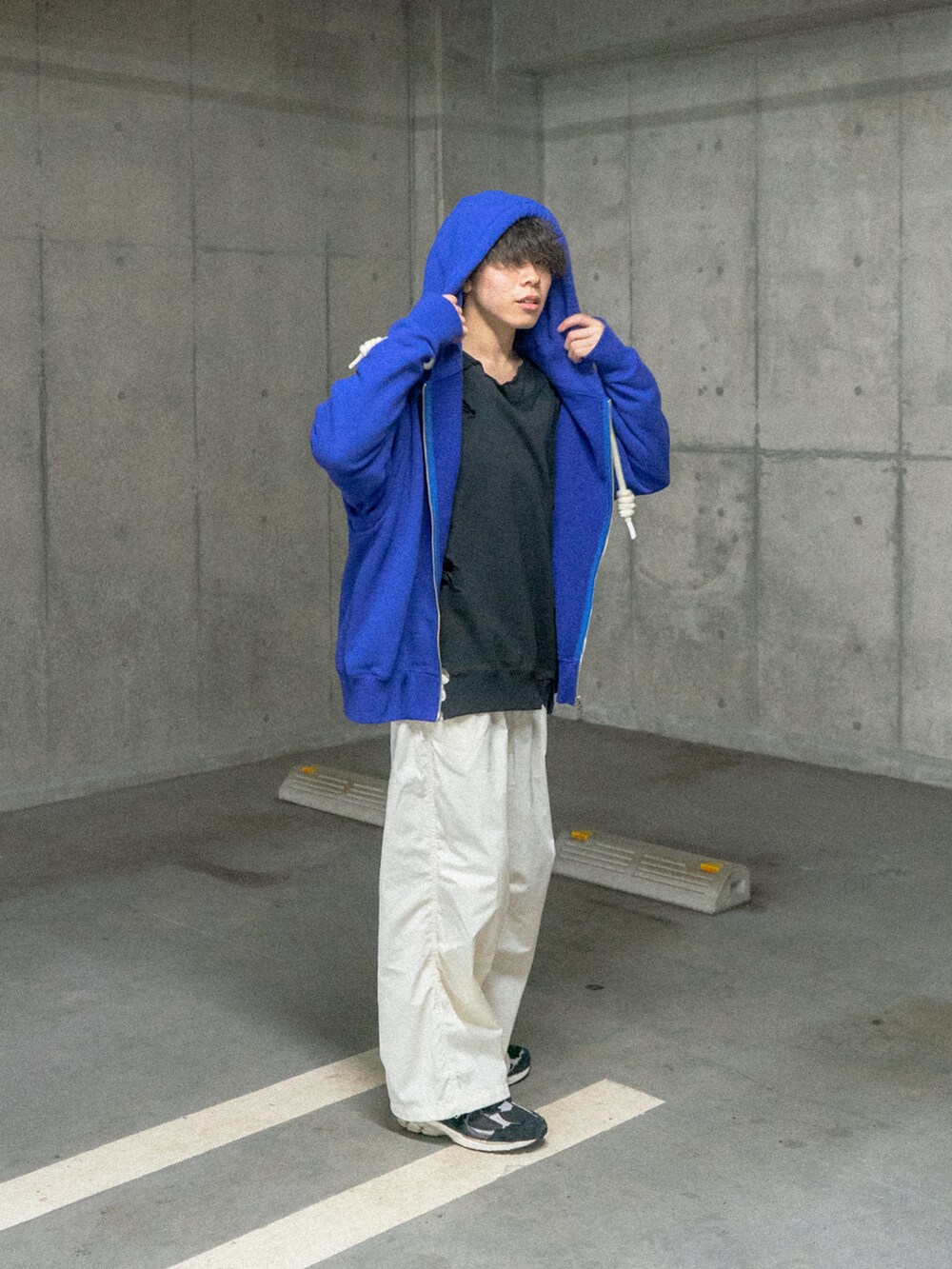 ブルー系のパーカー、ホワイト系のカーゴパンツ、ブラック系のスニーカーを着用したメンズの冬コーディネートの2枚目の写真