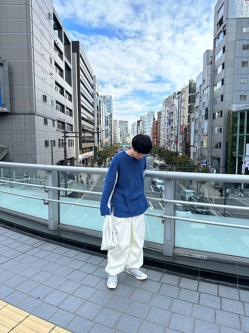 ブルー系のニット/セーター、ホワイト系のカーゴパンツ、グレー系のスニーカーを着用したメンズの秋コーディネートの3枚目の写真