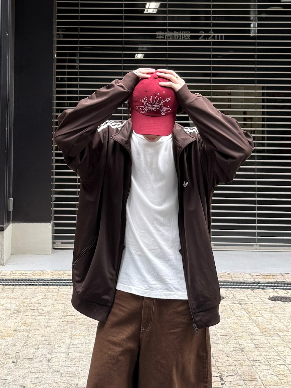 ブラウン系のジャージ、ホワイト系のTシャツ/カットソー、ブラウン系のデニムパンツを着用したメンズの春コーディネートの3枚目の写真