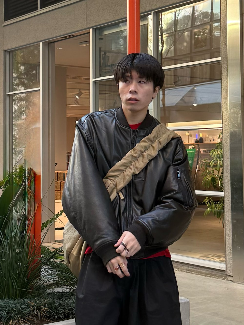 ブラウン系のMA-1、レッド系のニット/セーター、ブラック系のその他パンツを着用したメンズの冬コーディネートの2枚目の写真