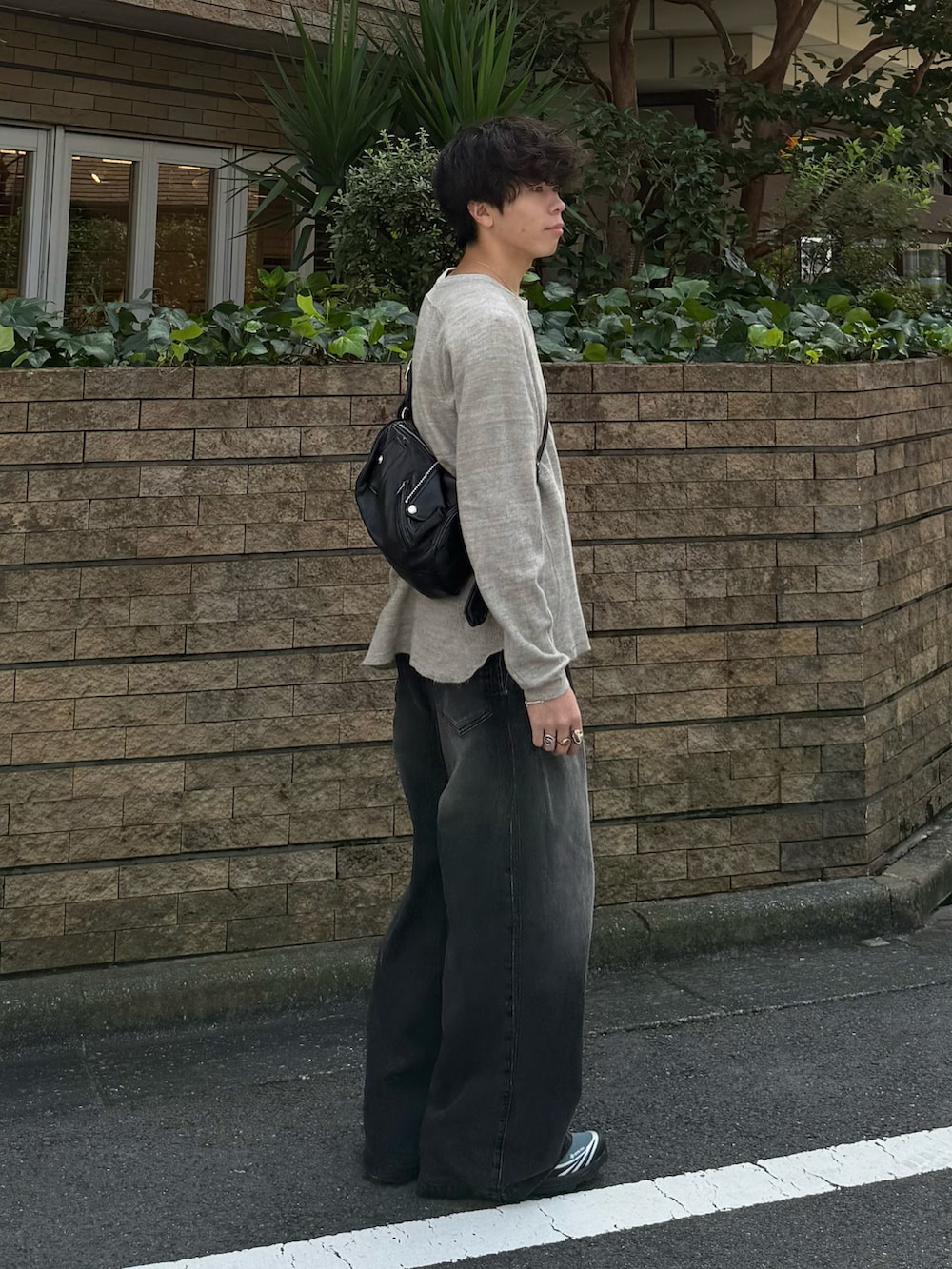 グレー系のTシャツ/カットソー、ブラック系のデニムパンツ、ブラック系のショルダーバッグを着用したメンズの秋コーディネートの2枚目の写真