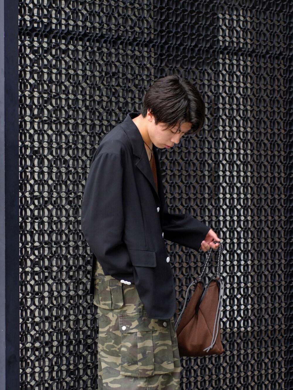 ブラック系のテーラードジャケット、ブラウン系のタンクトップ、その他のカーゴパンツを着用したメンズの夏コーディネートの3枚目の写真