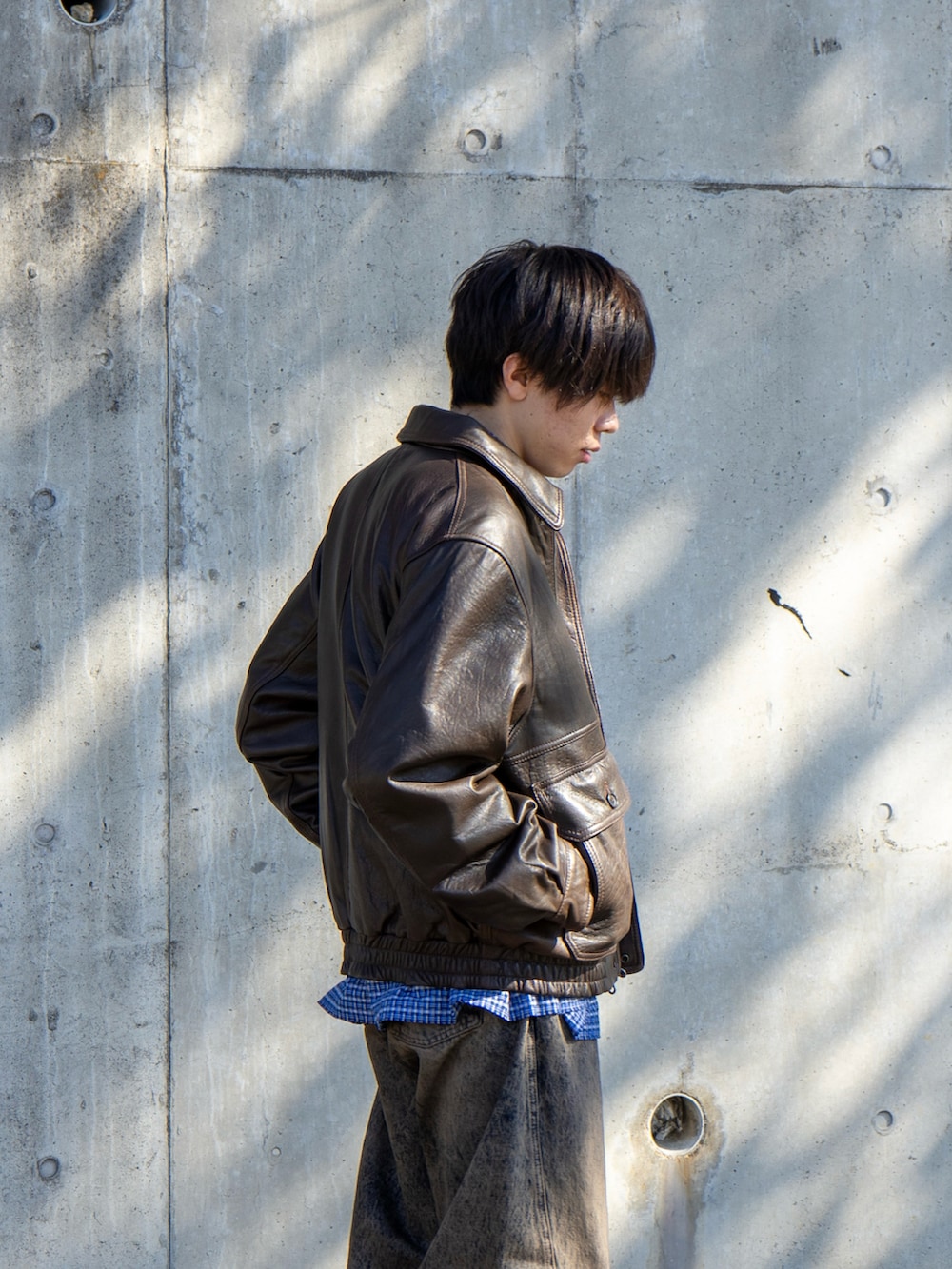 ブラウン系のブルゾン、ブルー系のデニムパンツ、ブルー系のシャツ/ブラウスを着用したメンズの秋コーディネートの3枚目の写真