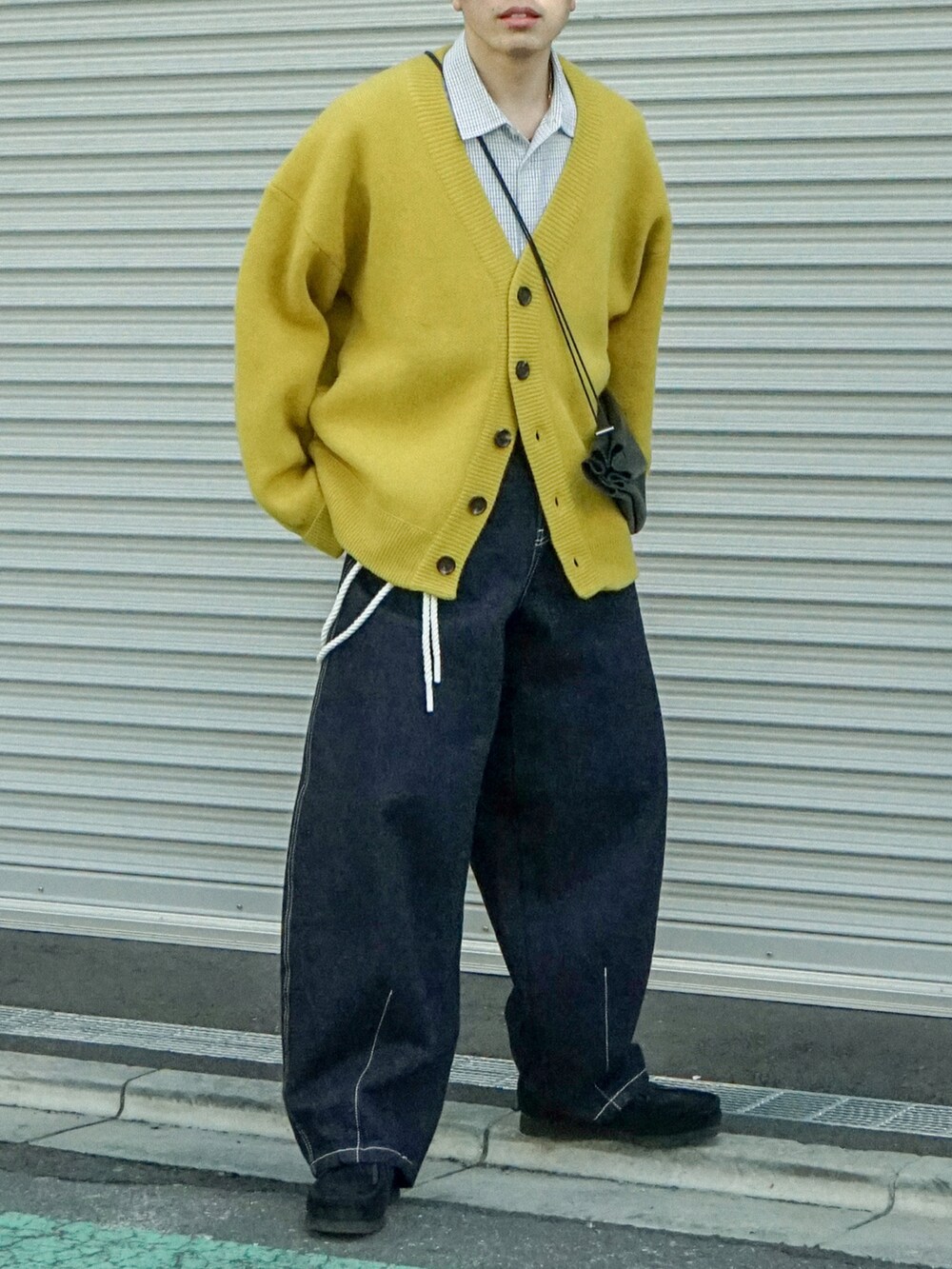 イエロー系のカーディガン/ボレロ、ブラック系のシャツ/ブラウス、ブルー系のデニムパンツを着用したメンズの冬コーディネートの5枚目の写真