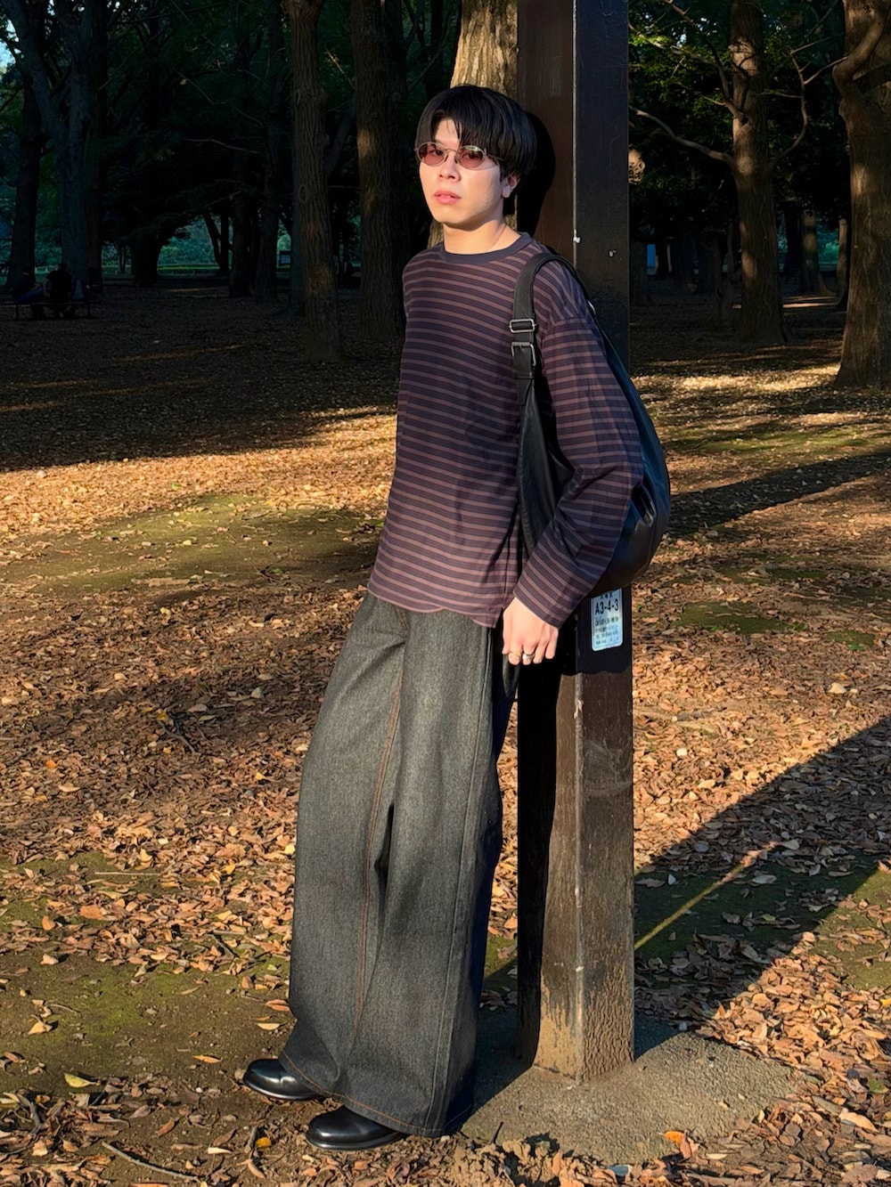 グレー系のTシャツ/カットソー、ブラック系のデニムパンツ、ブラック系のブーツを着用したメンズの秋コーディネートの2枚目の写真